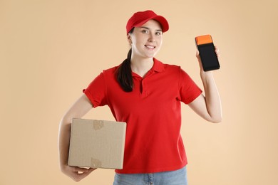 Happy courier with payment terminal and parcel on beige background