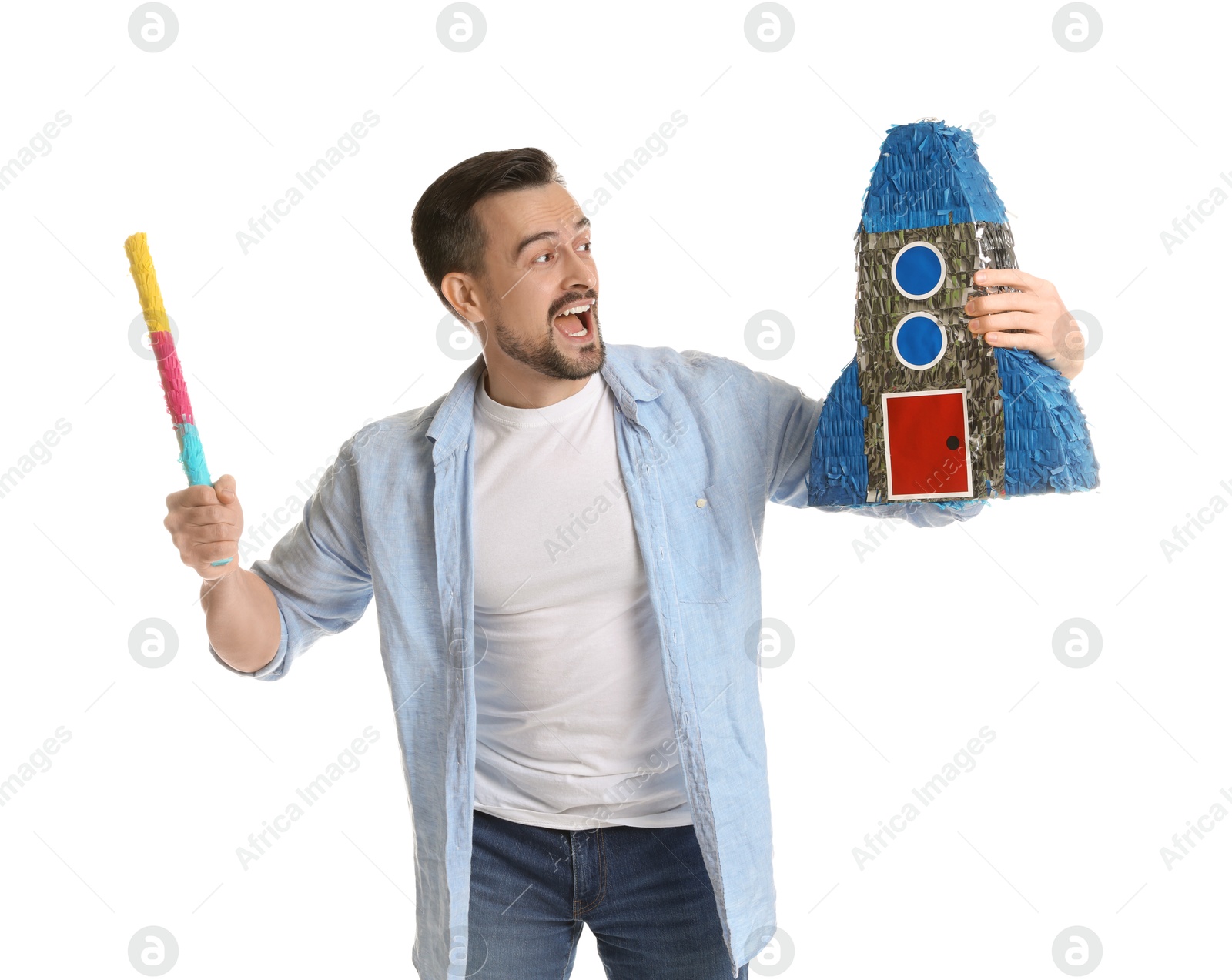 Photo of Emotional man hitting rocket shaped pinata with stick on white background