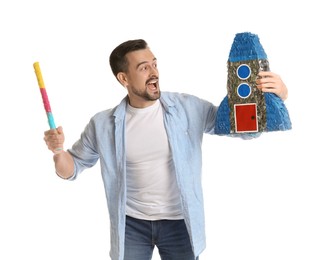 Photo of Emotional man hitting rocket shaped pinata with stick on white background