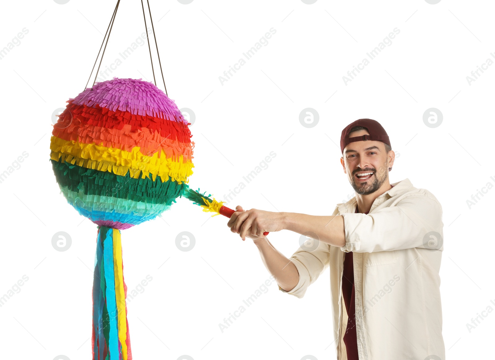 Photo of Emotional man hitting colorful pinata with stick on white background