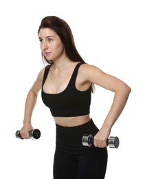 Woman in sportswear exercising with dumbbells on white background