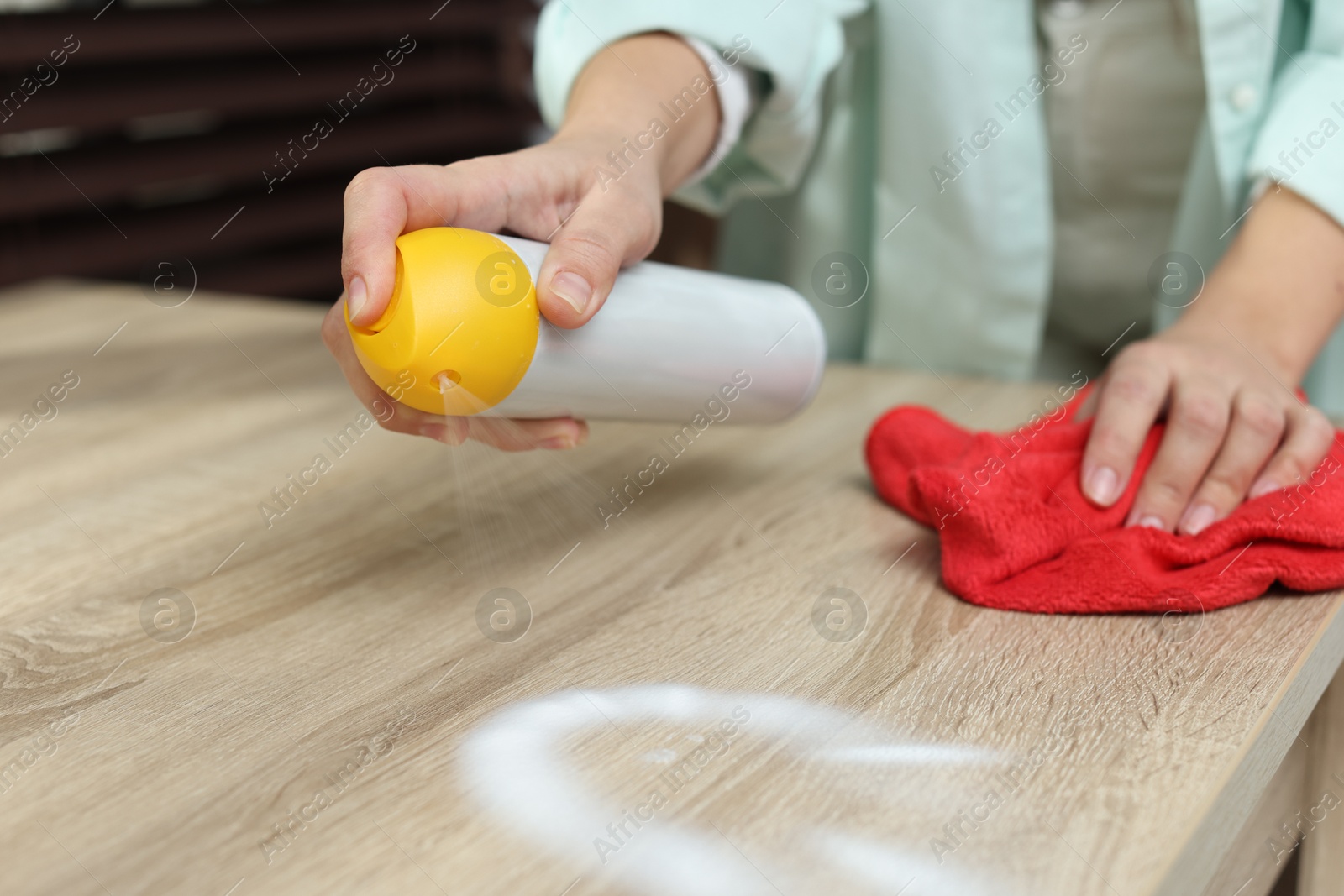 Photo of Woman polishing wooden table at home, closeup