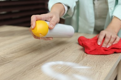 Photo of Woman polishing wooden table at home, closeup