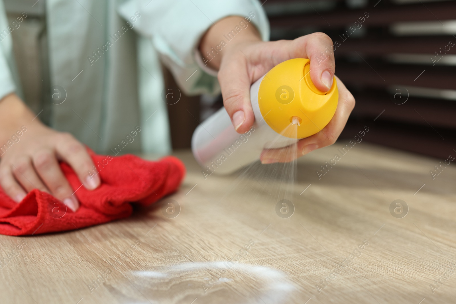 Photo of Woman polishing wooden table at home, closeup