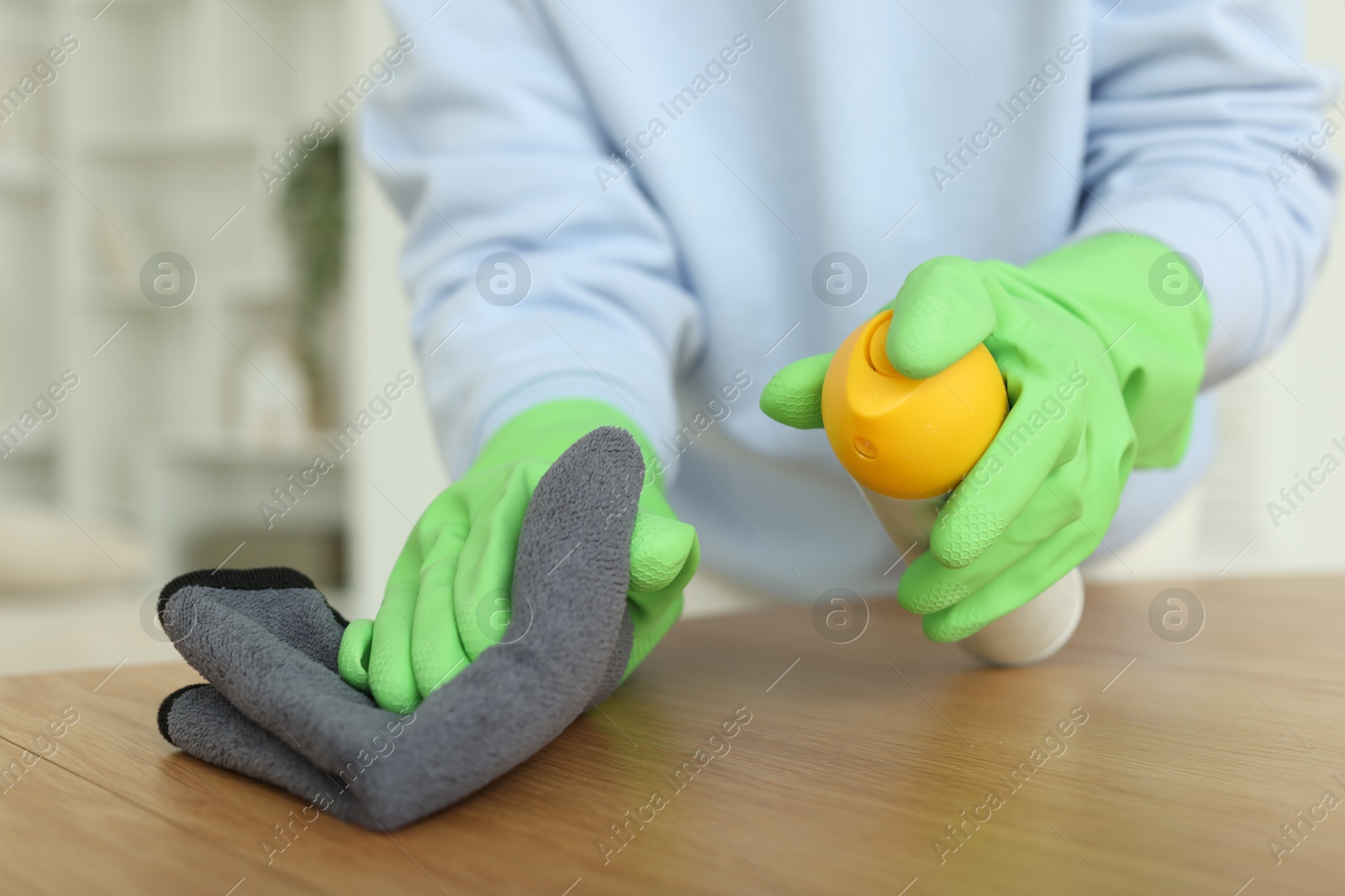 Photo of Woman polishing wooden table at home, closeup