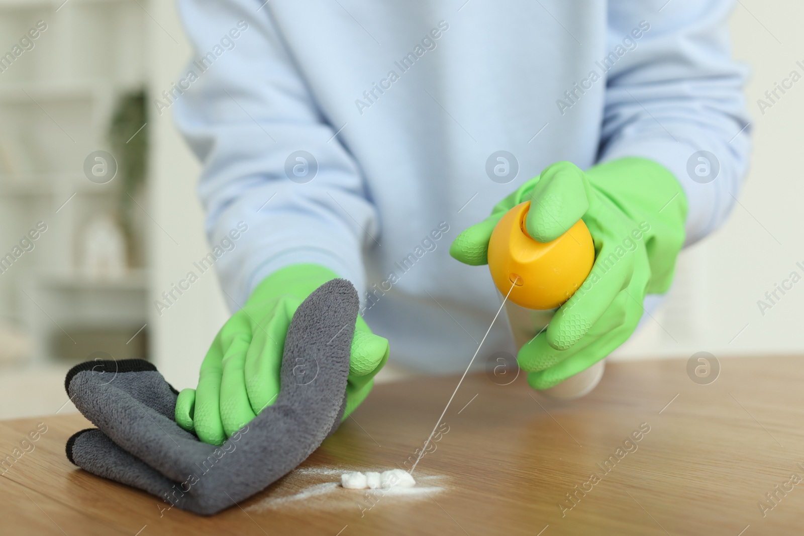 Photo of Woman polishing wooden table at home, closeup