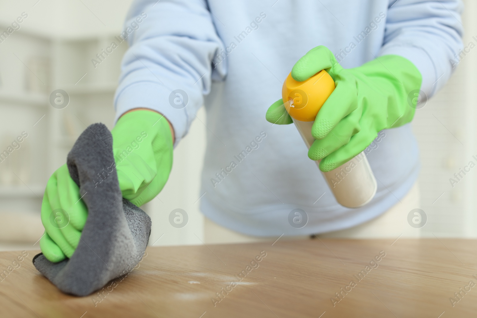 Photo of Woman polishing wooden table at home, closeup