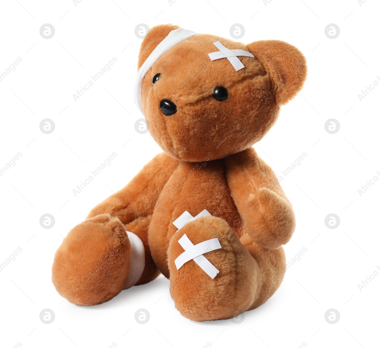 Photo of Teddy bear with bandages and adhesive medical plasters isolated on white