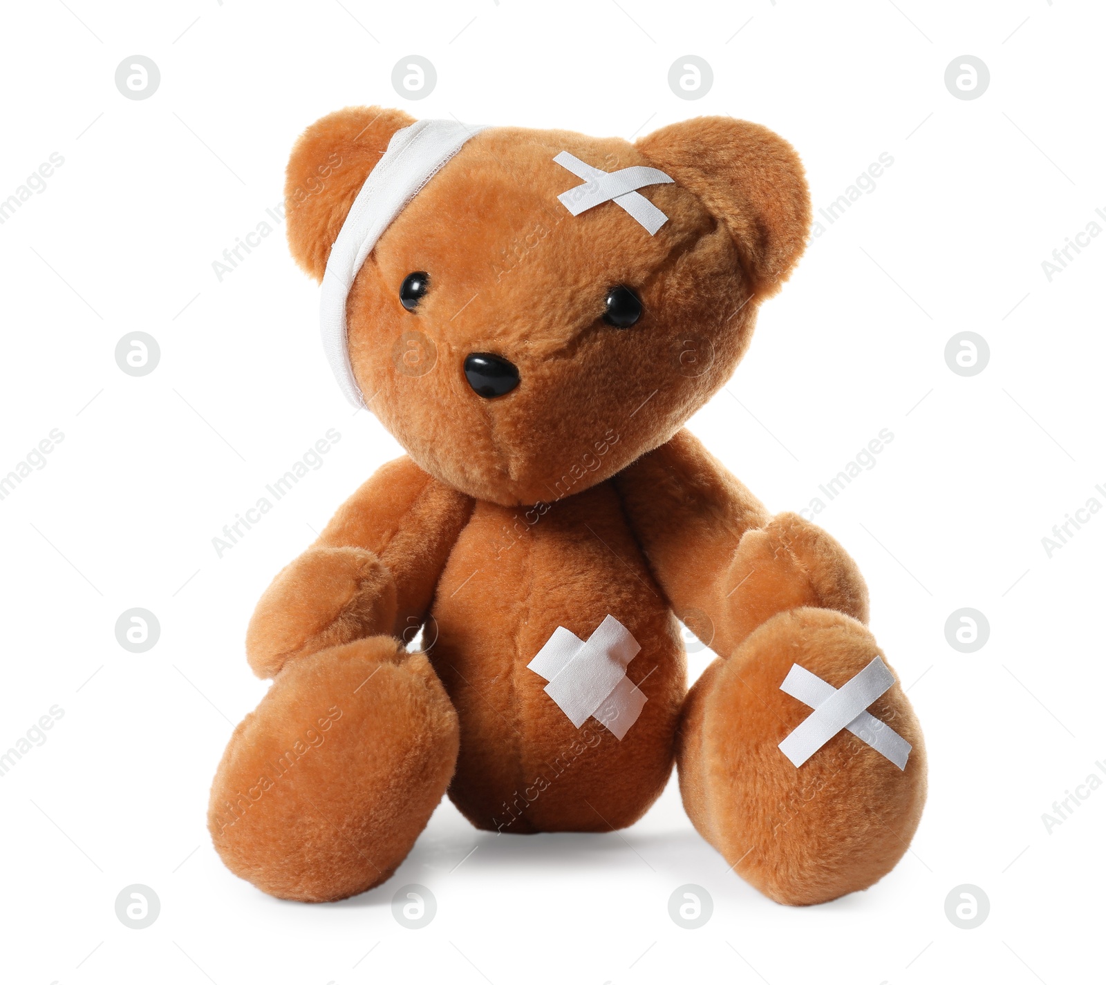 Photo of Teddy bear with bandages and adhesive medical plasters isolated on white