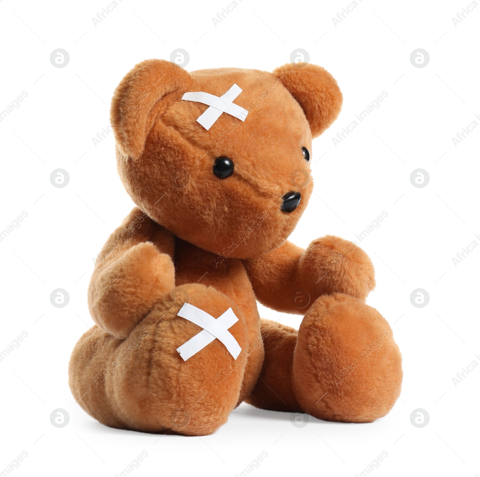 Photo of Teddy bear with adhesive medical bandages isolated on white