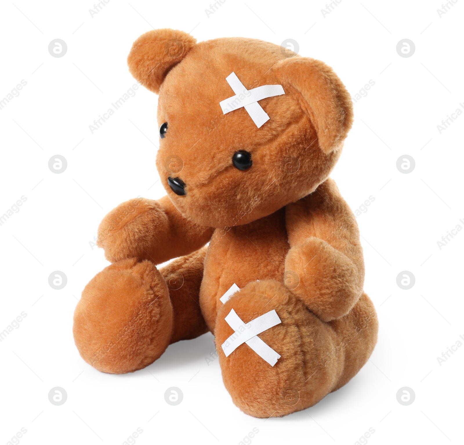 Photo of Teddy bear with adhesive medical bandages isolated on white