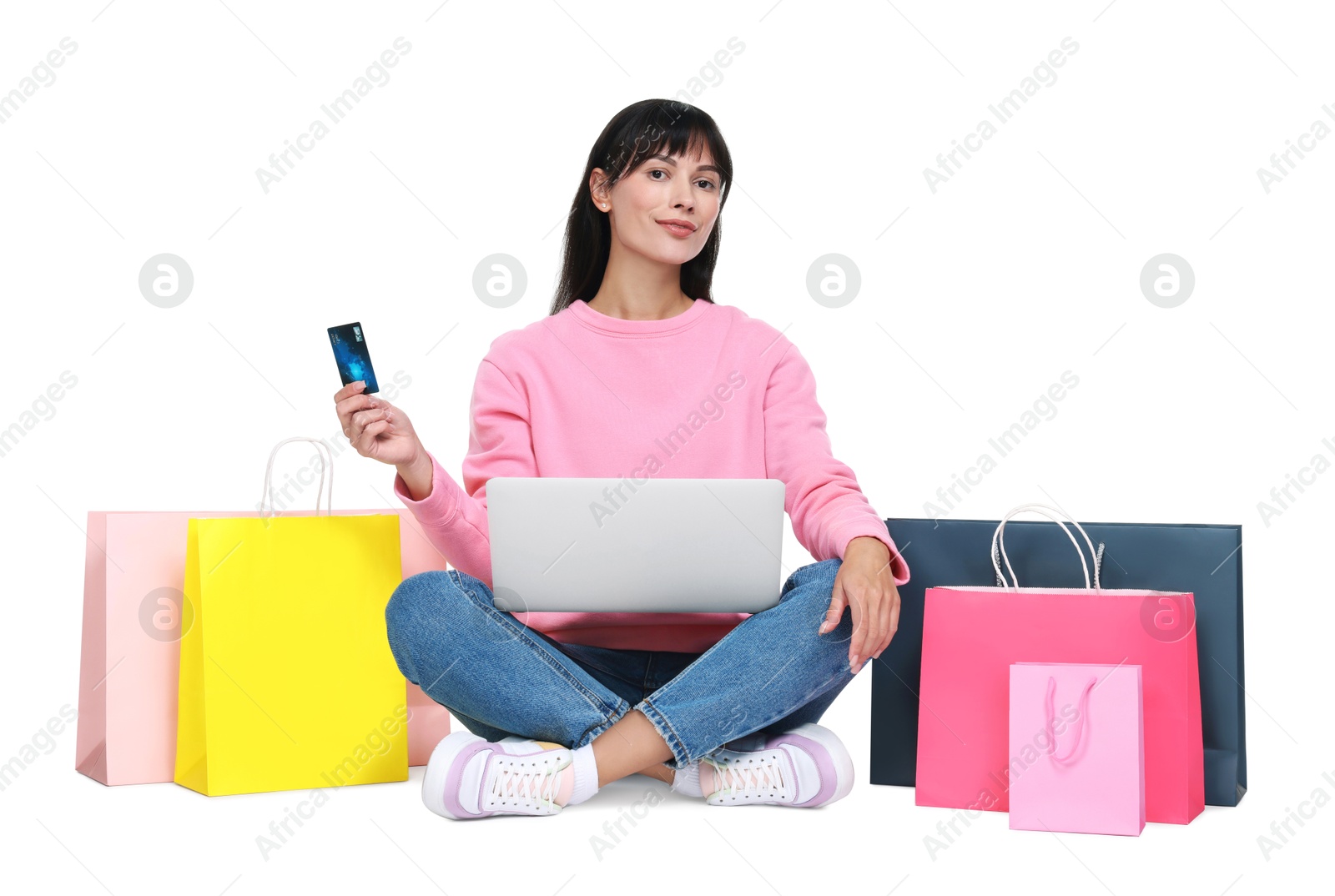 Photo of Internet shopping. Beautiful woman with credit card, laptop and colorful bags on white background