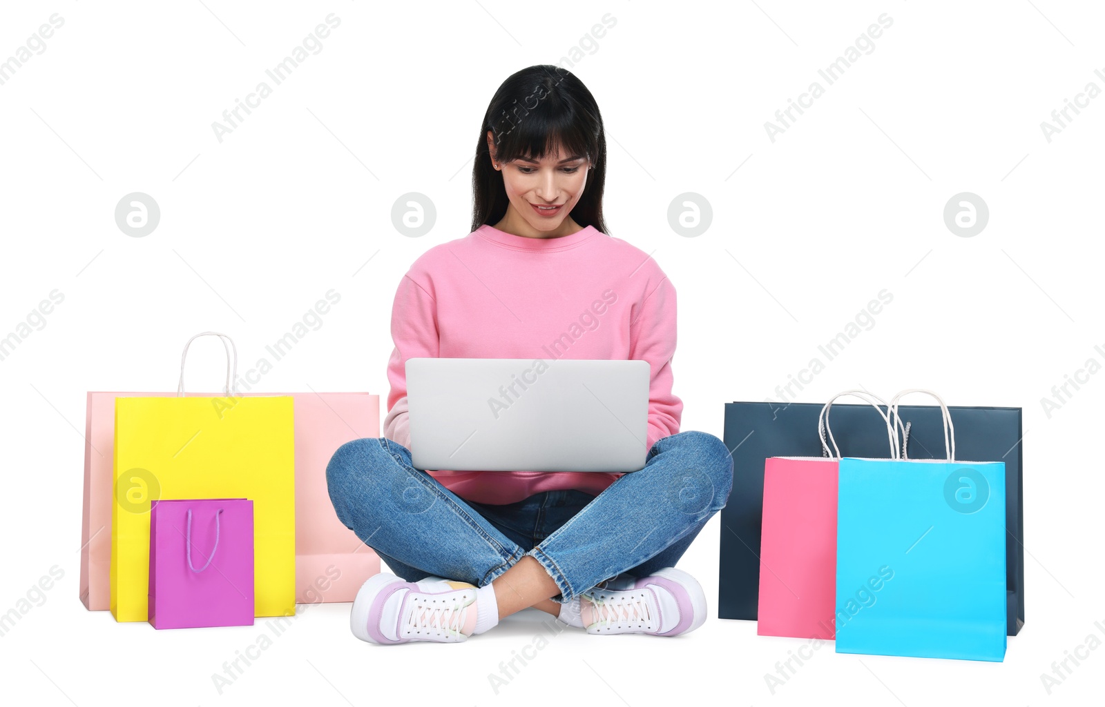 Photo of Internet shopping. Beautiful woman with laptop and colorful bags on white background