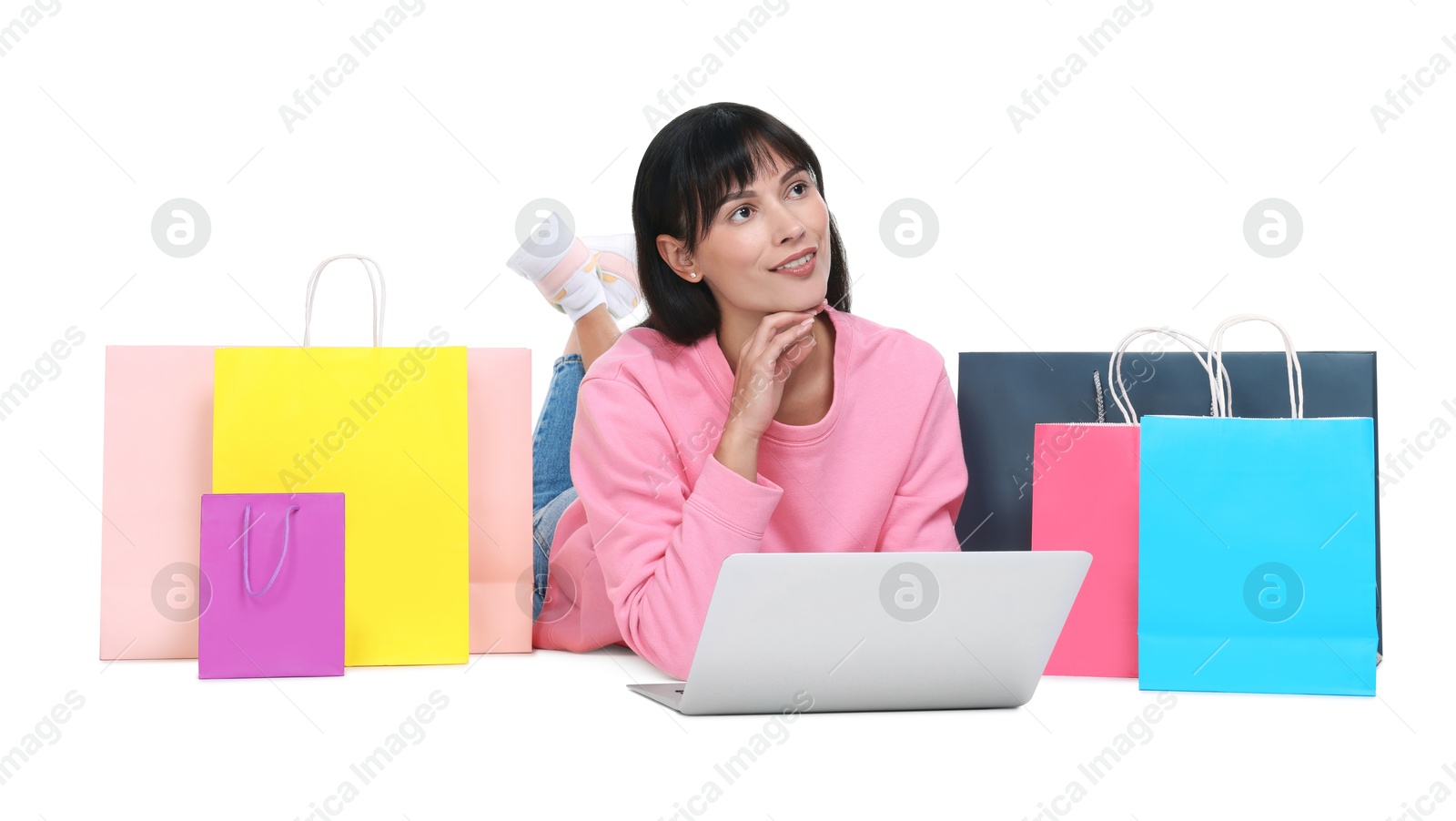 Photo of Internet shopping. Smiling woman with laptop and colorful bags on white background