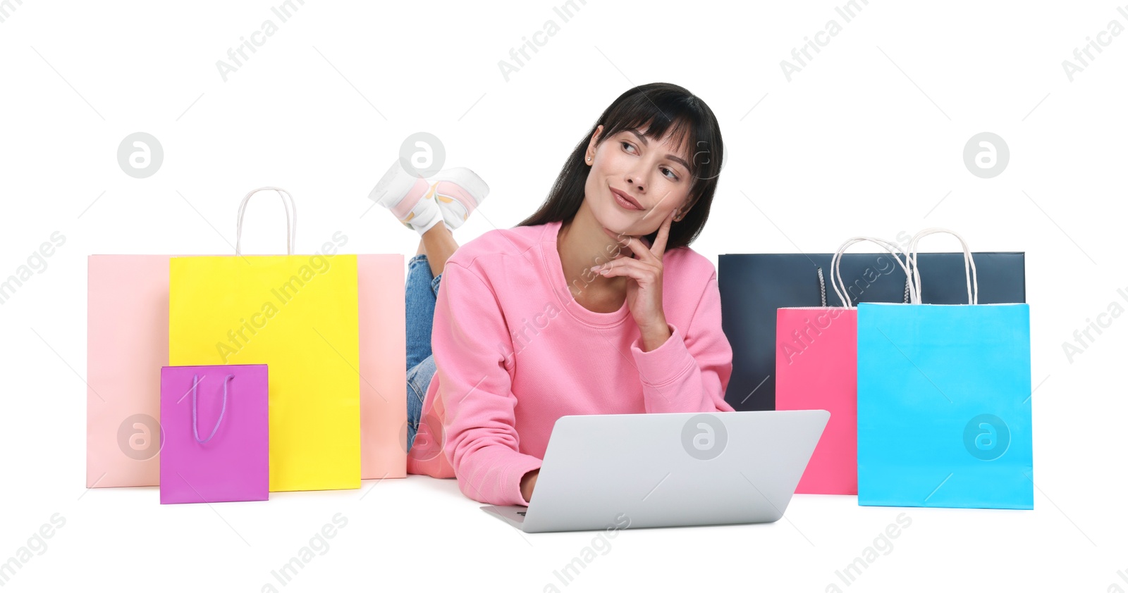 Photo of Internet shopping. Beautiful woman with laptop and colorful bags on white background