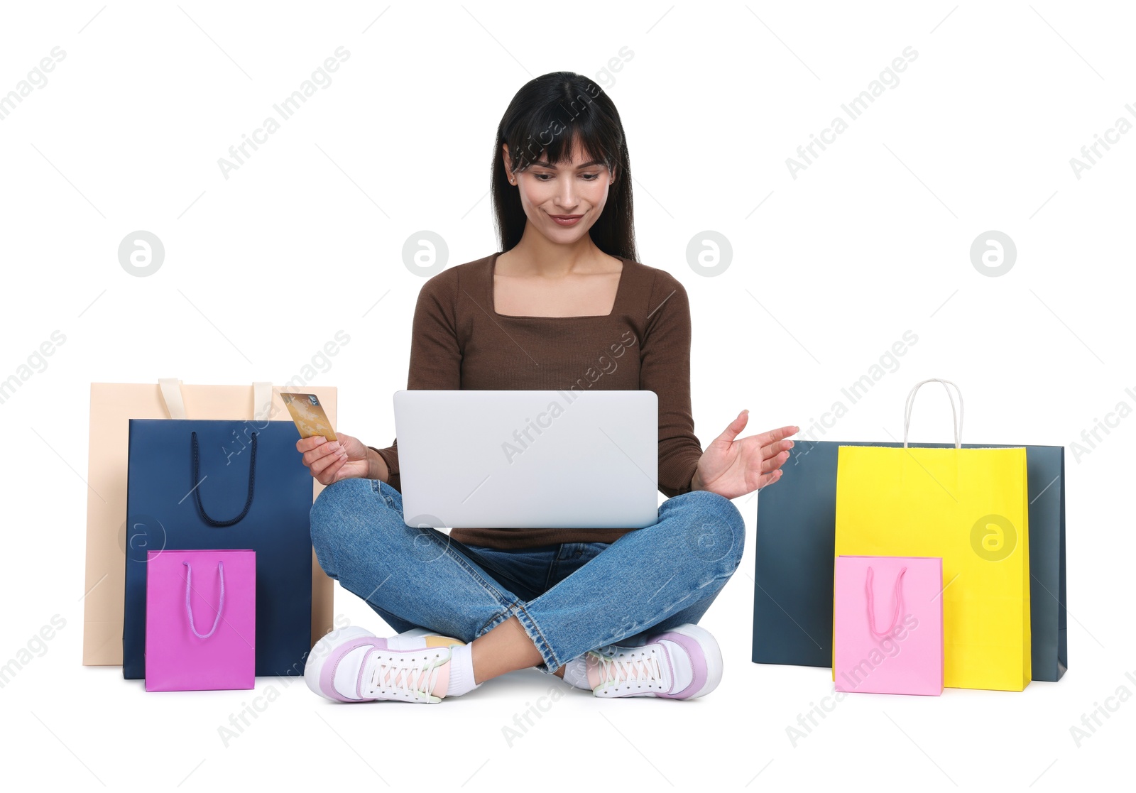 Photo of Internet shopping. Beautiful woman with credit card, laptop and colorful bags on white background