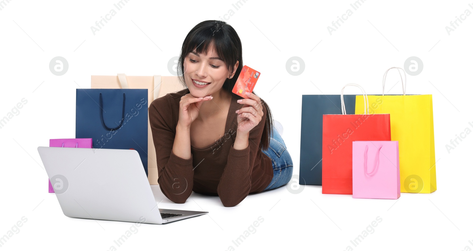 Photo of Internet shopping. Happy woman with credit card, laptop and colorful bags on white background