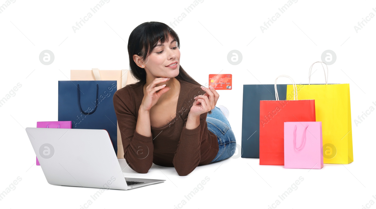 Photo of Internet shopping. Happy woman with credit card, laptop and colorful bags on white background