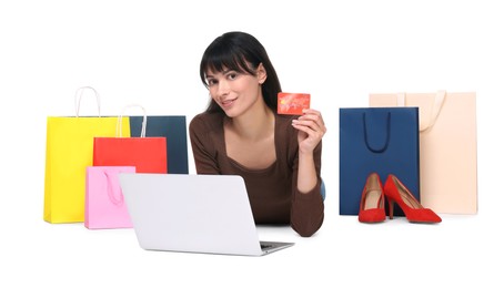 Internet shopping. Happy woman with credit card, laptop and colorful bags on white background