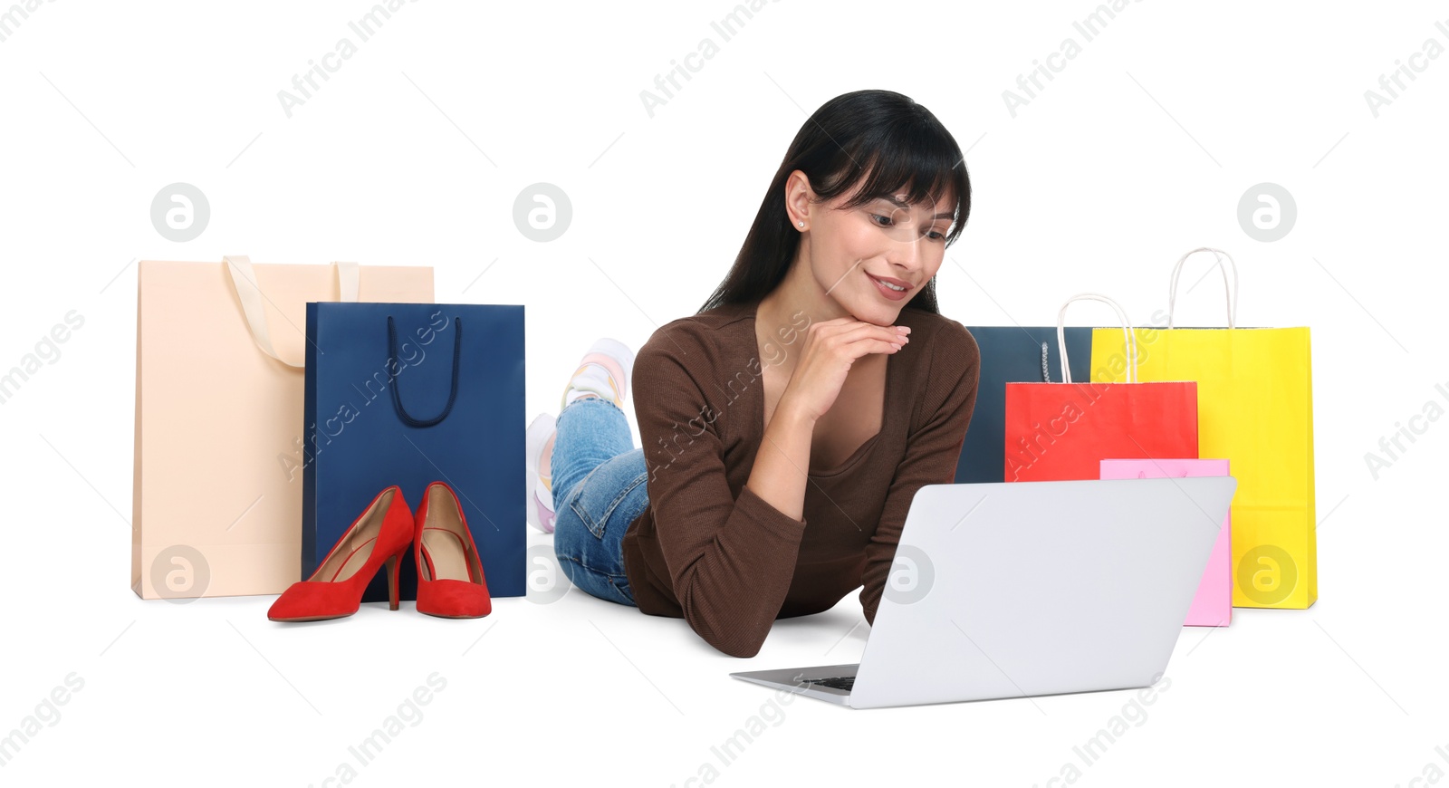 Photo of Internet shopping. Happy woman with laptop and colorful bags on white background