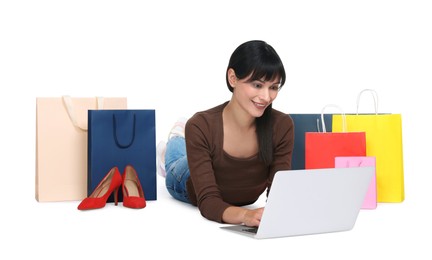 Internet shopping. Happy woman with laptop and colorful bags on white background