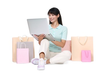 Internet shopping. Happy woman with laptop and colorful bags on white background