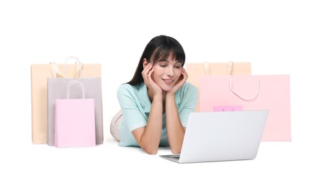 Internet shopping. Happy woman with laptop and colorful bags on white background