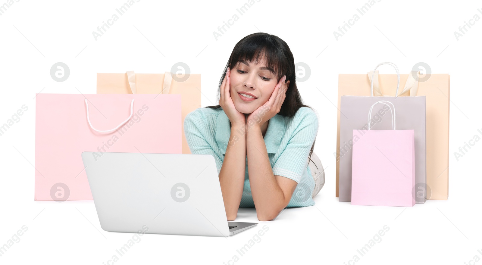 Photo of Internet shopping. Happy woman with laptop and colorful bags on white background