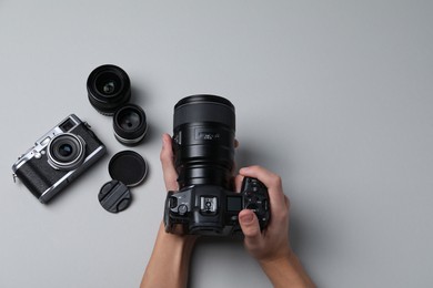 Photo of Photographer with professional camera on grey background, top view