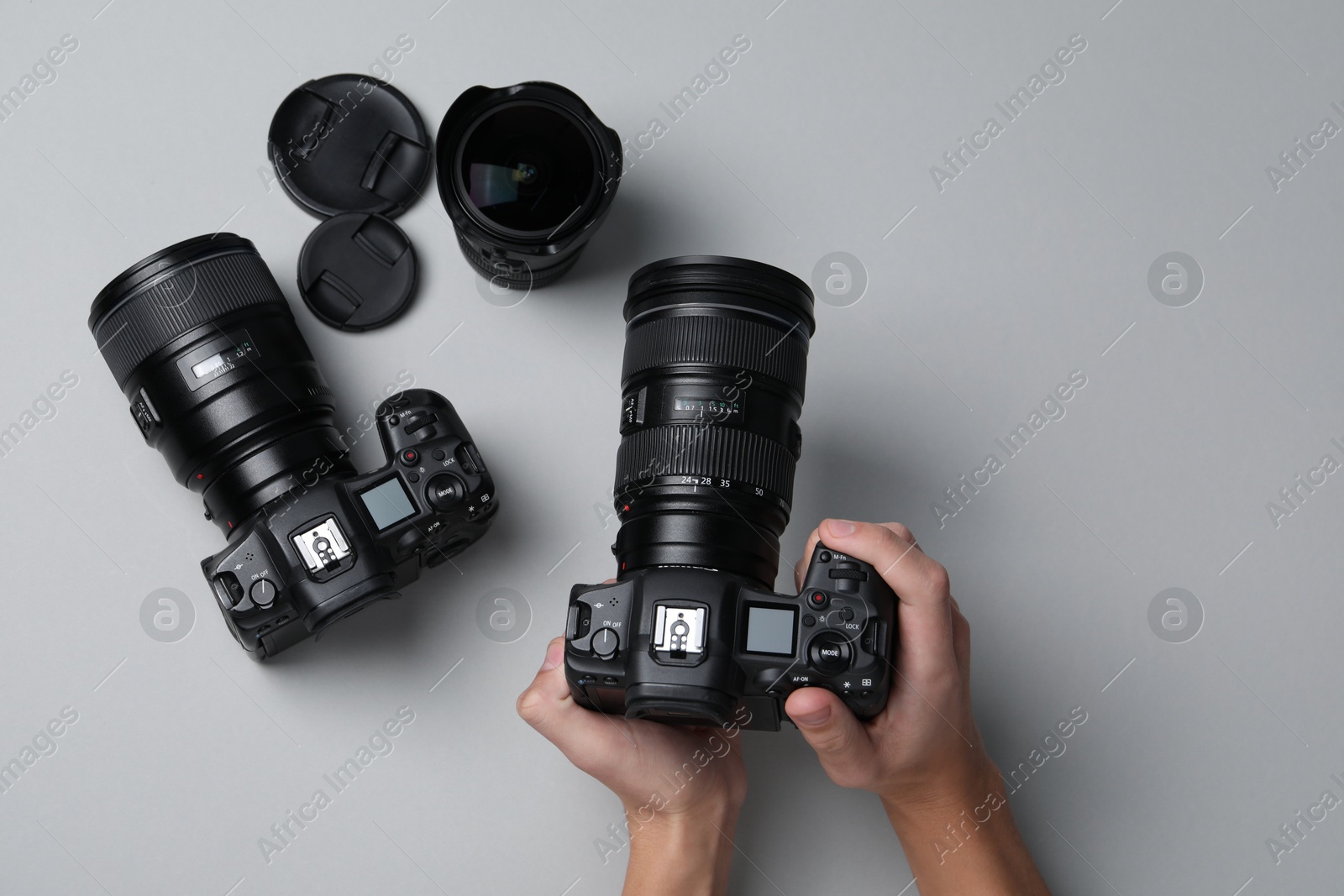 Photo of Photographer with professional camera on grey background, top view