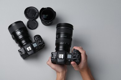 Photo of Photographer with professional camera on grey background, top view