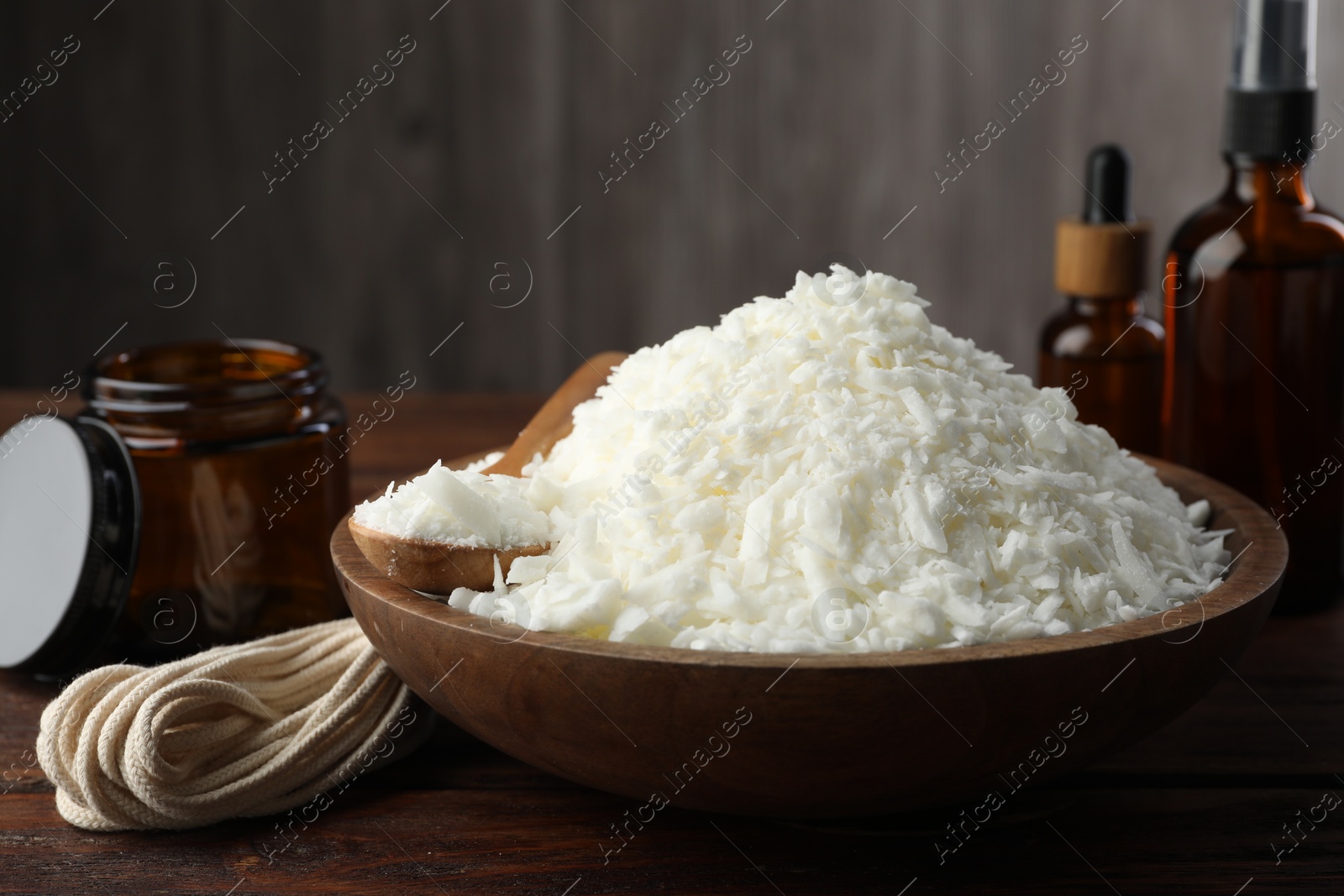 Photo of Soy wax and other supplies for making candles on wooden table, closeup