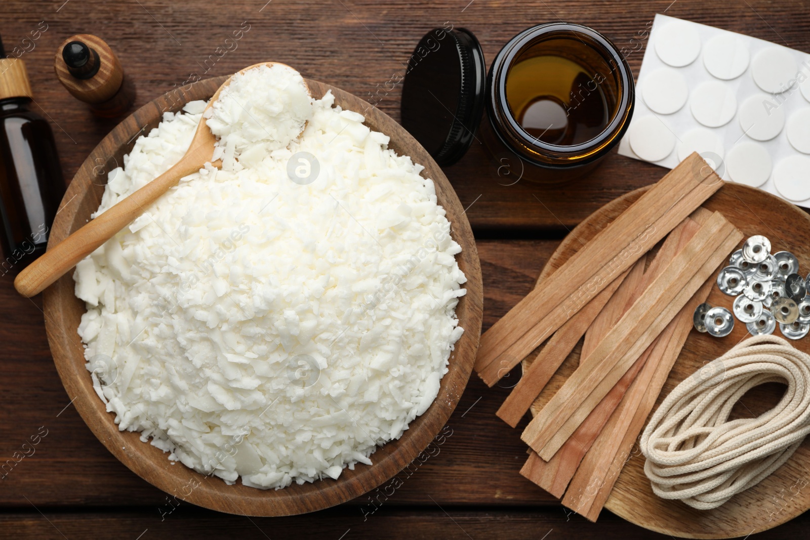 Photo of Soy wax and other supplies for making candles on wooden table, flat lay