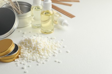 Photo of Soy wax and other supplies for making candles on white table. Space for text