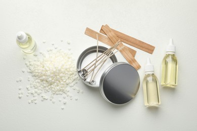 Photo of Soy wax and other supplies for making candles on white table, flat lay