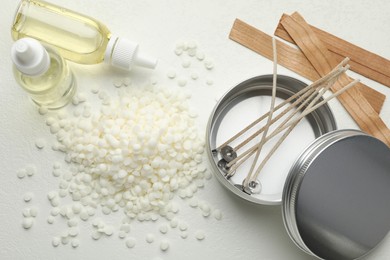 Photo of Soy wax and other supplies for making candles on white table, flat lay