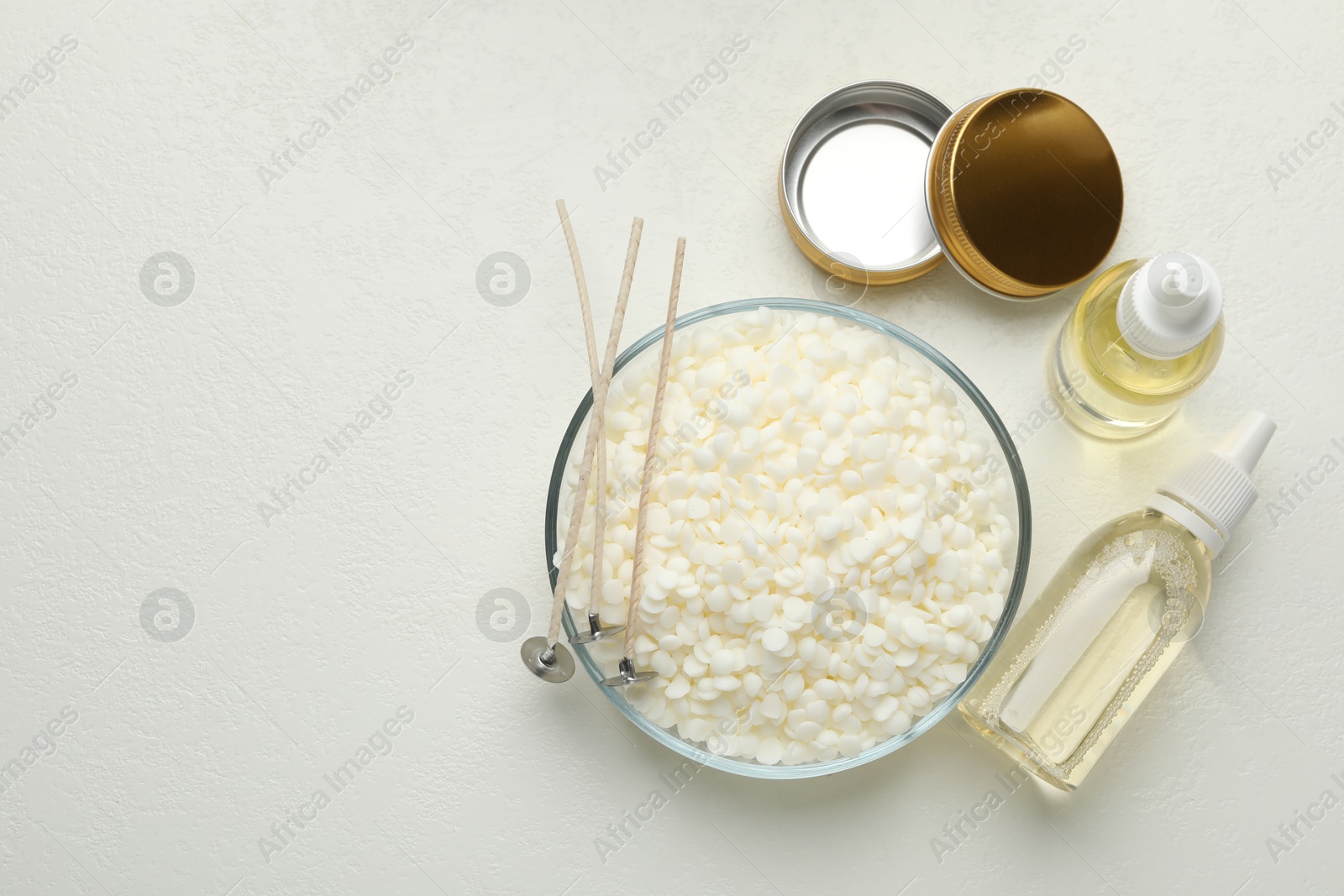 Photo of Soy wax and other supplies for making candles on white table, flat lay. Space for text