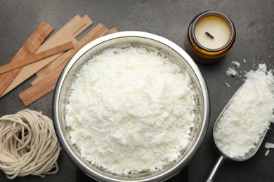 Photo of Soy wax and other supplies for making candles on grey table, flat lay