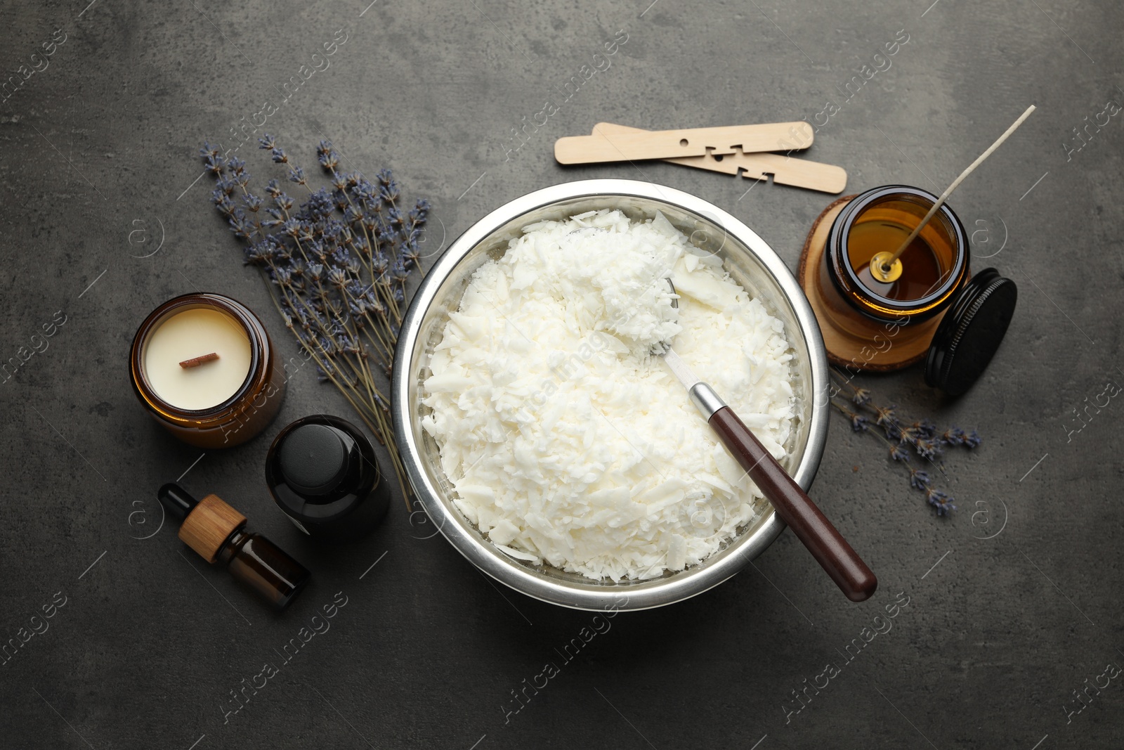 Photo of Soy wax and other supplies for making candles on grey table, flat lay