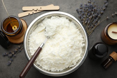 Photo of Soy wax and other supplies for making candles on grey table, flat lay