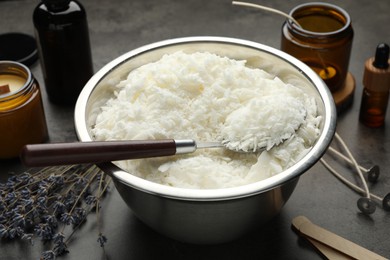 Photo of Soy wax and other supplies for making candles on grey table, closeup