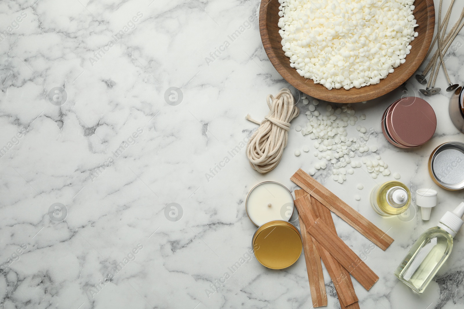 Photo of Soy wax and other supplies for making candles on white marble table, flat lay. Space for text