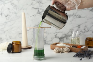 Photo of Woman making soy wax candle at white wooden table, closeup