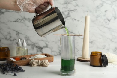 Photo of Woman making soy wax candle at white wooden table, closeup