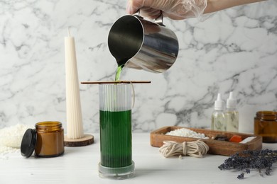 Photo of Woman making soy wax candle at white wooden table, closeup