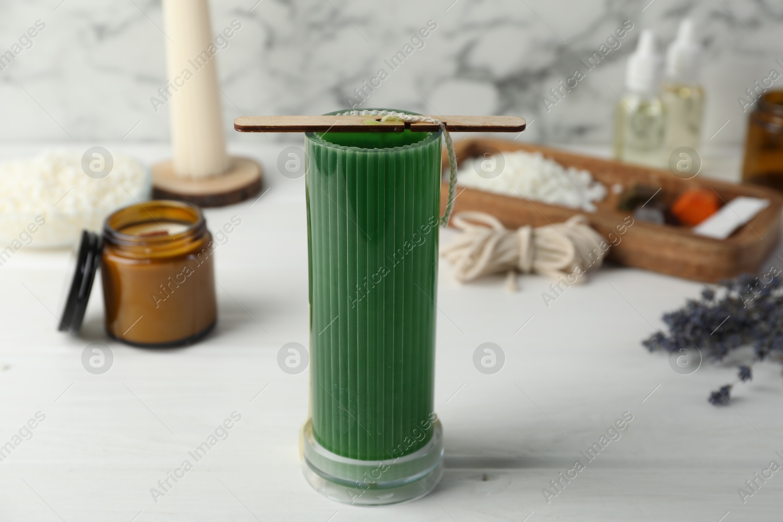 Photo of Soy wax candle with stabilizer on white wooden table, closeup