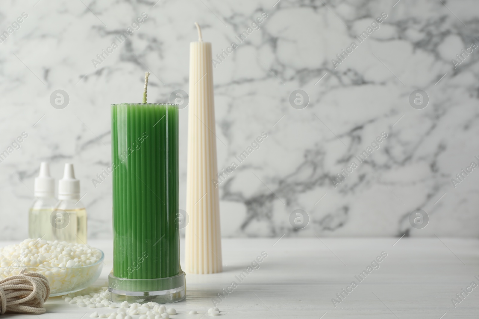 Photo of Soy wax candles on white wooden table, space for text