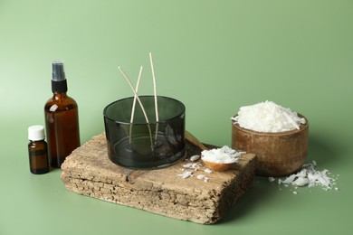 Photo of Soy wax, essential oils, different tools for making candles and piece of wood on green background