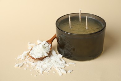 Photo of Soy wax, candle and spoon on beige background, closeup