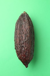 Cocoa pod on green background, top view